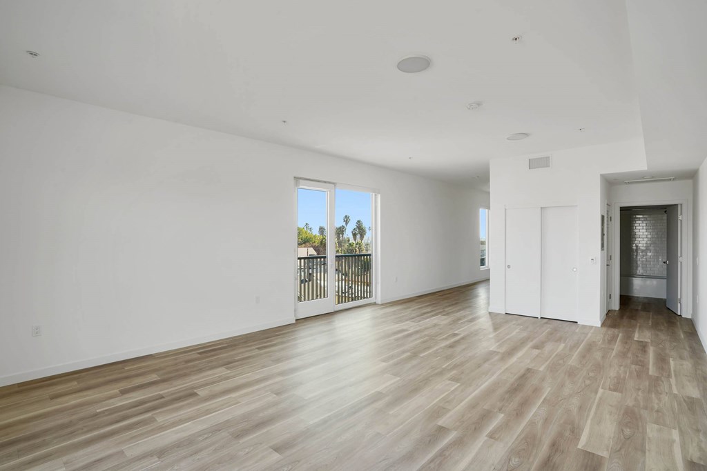 A spacious room with wooden flooring and white walls.at 2221 S Western, California