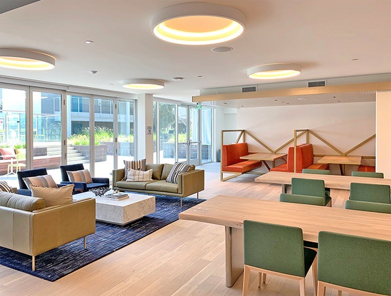 A modern living room with a sofa set, a coffee table, and a dining table.