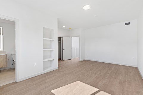 A room with a white wall and a brown rug on the floor.