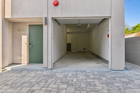 A building entrance with a green door and a red sign above it.