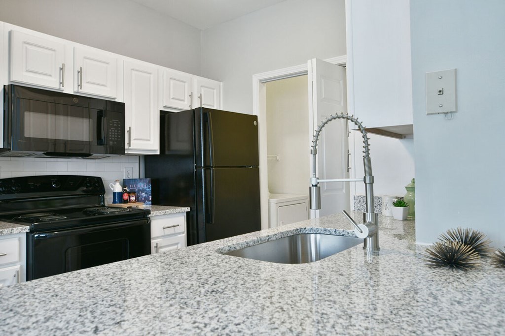 A kitchen with black appliances and white cabinets.at Braxton Woods Lake, Greenville, 29607