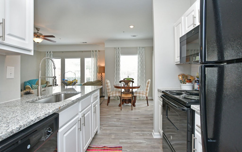A kitchen with white cabinets and black appliances.at Braxton Woods Lake, Greenville, SC 29607