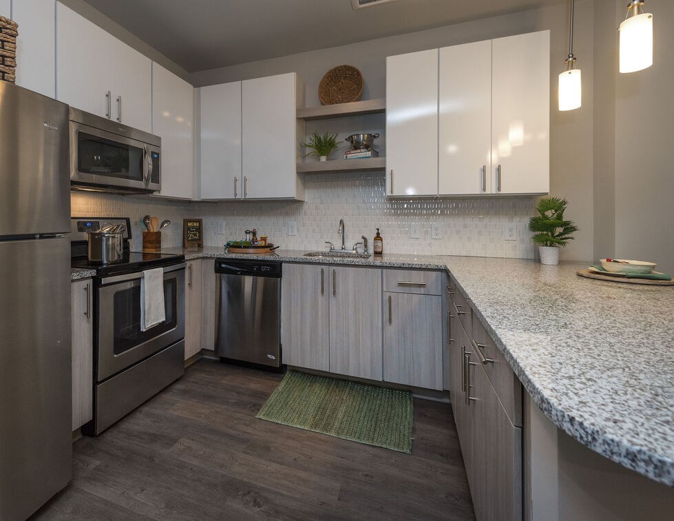 A modern kitchen with stainless steel appliances and white cabinets. at Mariner Grove, Savannah, 31404