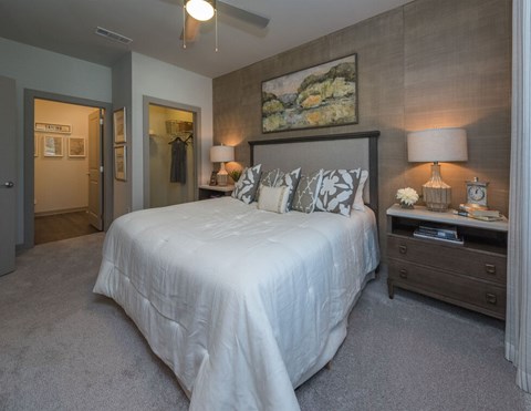 A bedroom with a large bed and a painting on the wall.