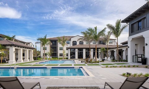 A swimming pool surrounded by lounge chairs at Las Palmas Apartments, Fort Myers, FL 33913