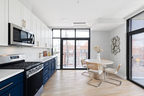 A kitchen with a table and chairs and a window.