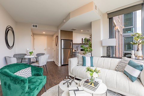 A living room with a green chair and a white couch.