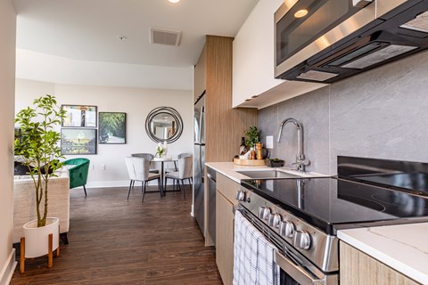 A modern kitchen with a stainless steel oven and a dining table with chairs.