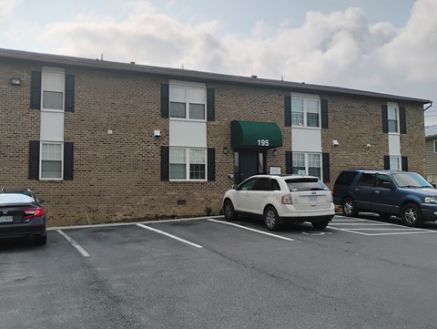 A parking lot in front of a building with the number 195 on it.