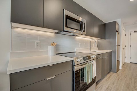 A modern kitchen with a stainless steel oven and microwave.