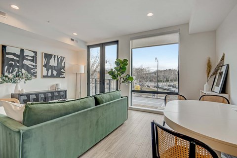 A living room with a green couch and a white table.