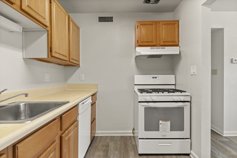 A kitchen with a white oven and a white sink.