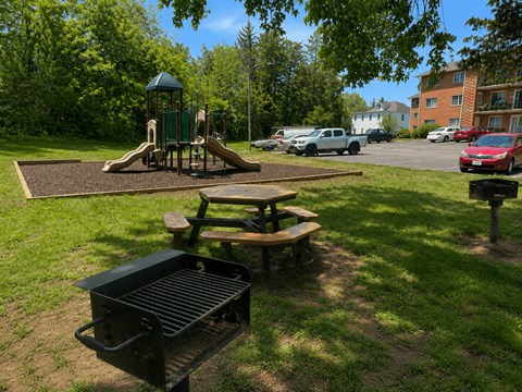 A playground with a slide and a picnic table.