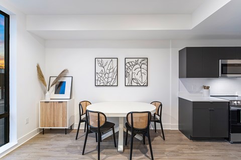 A dining room with a white table and chairs.