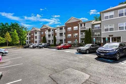 A parking lot with cars and apartment buildings in the background.