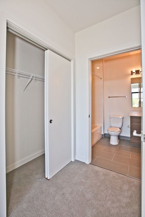 A white door is open to a bathroom with a toilet and sink.