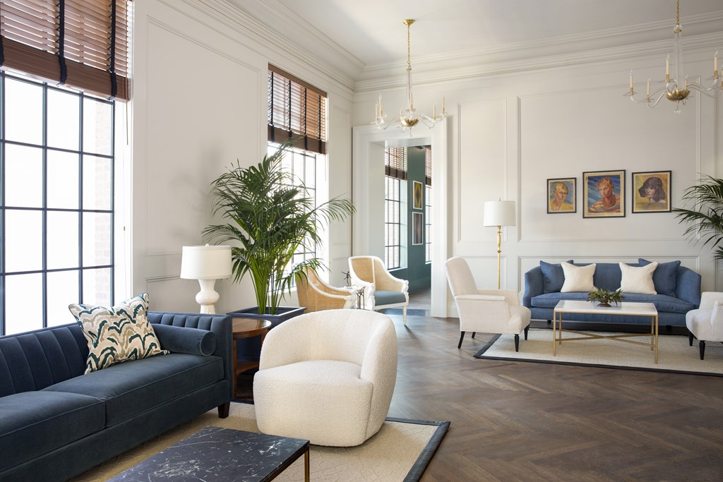 A living room with a dark blue couch and a white chair.