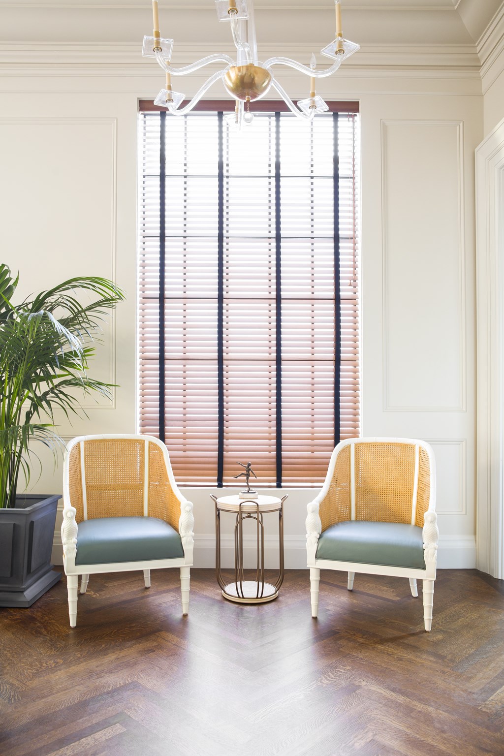 Two chairs are placed in front of a window with blinds.