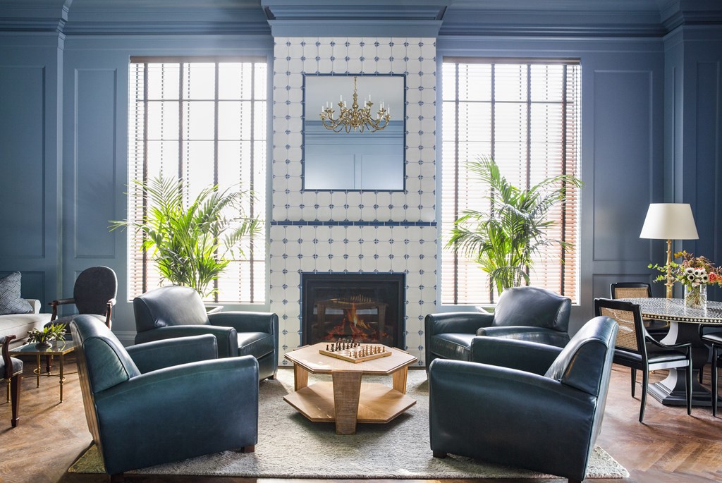 A living room with a fireplace and blue chairs.