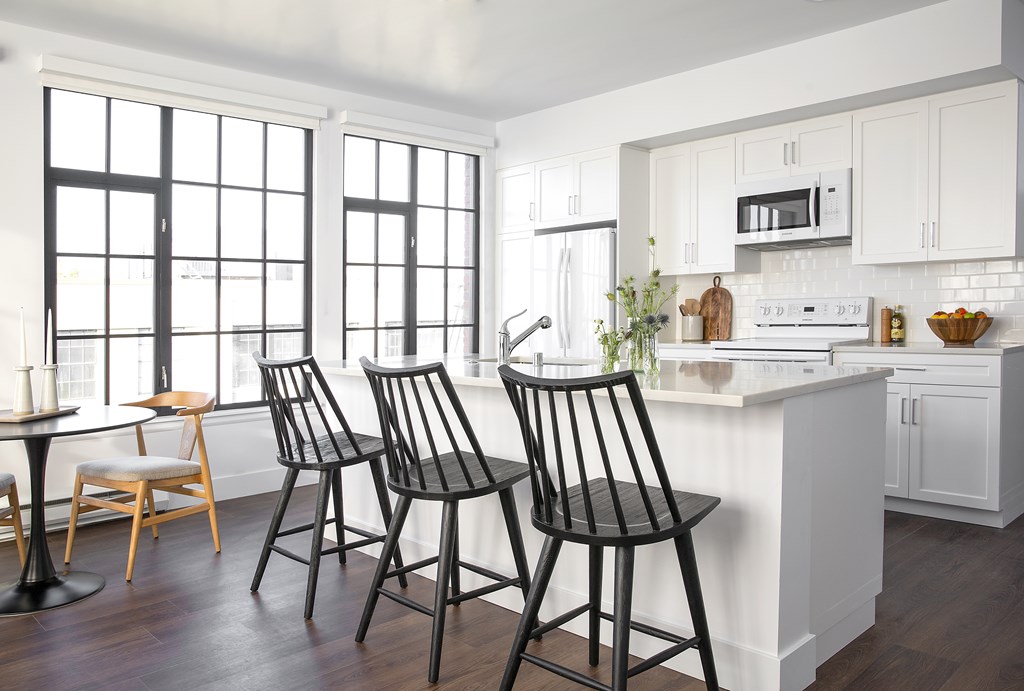 A kitchen with white cabinets and a white counter top.