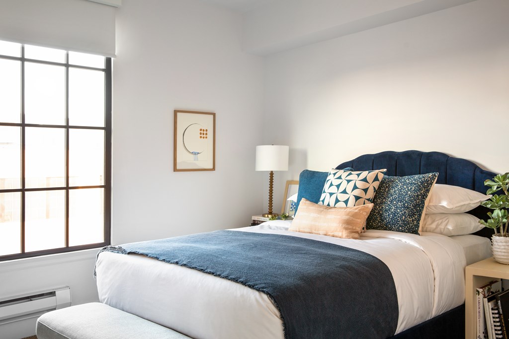 A bedroom with a large bed and a window.
