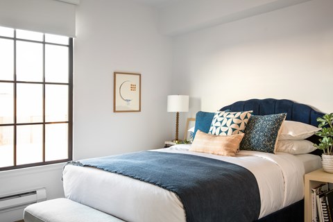 A bedroom with a large bed and a window.