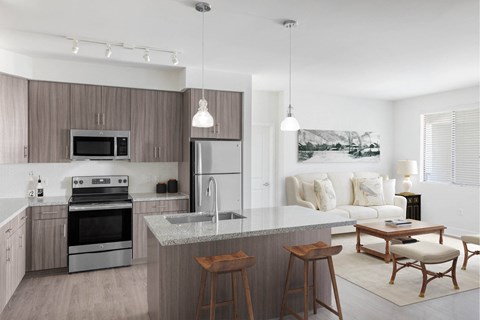 A modern kitchen with a large island and a dining area.