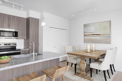 A modern kitchen with a wooden table and chairs.