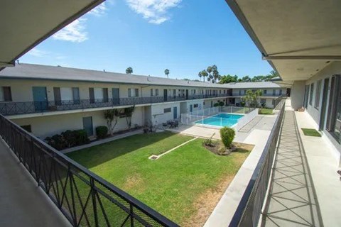 A view of a pool from a balcony of a building.