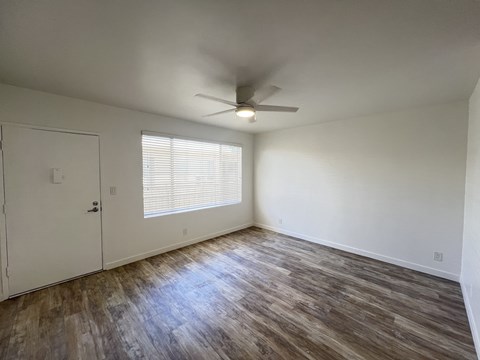 A room with a ceiling fan and a door.