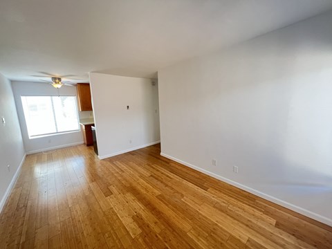 Empty room with wooden flooring and a window.