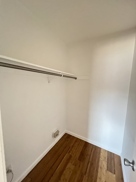 A white wall with a wooden floor and a door.