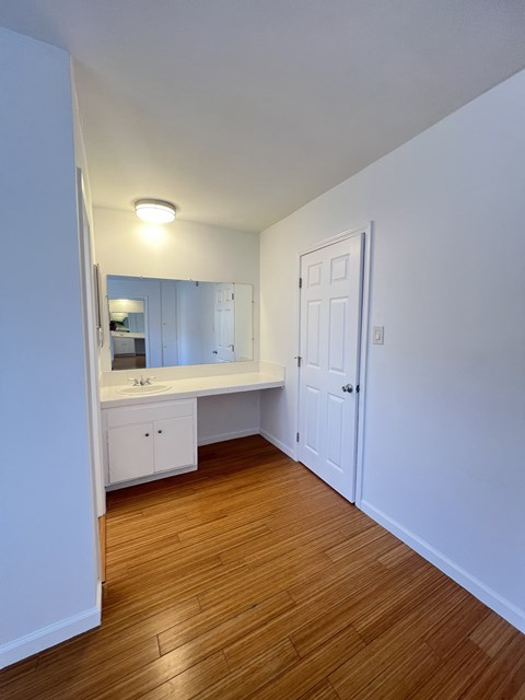 A white bathroom with a sink and mirror.