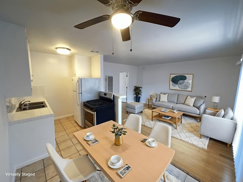 A well-lit, spacious living room with a dining table set for two.