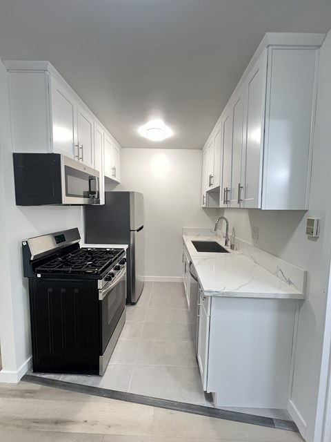 A kitchen with black and white appliances and cabinets.