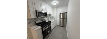 A kitchen with a stove, microwave, and refrigerator.