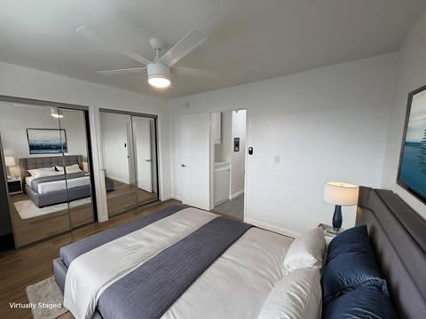 A bedroom with a large bed and a ceiling fan.