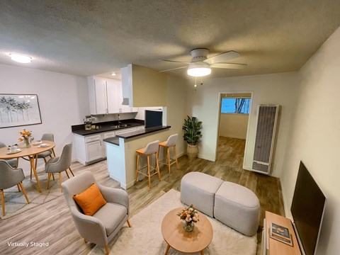 A living room with a grey couch, a brown coffee table, and a television.