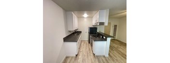 A kitchen with white cabinets and a black countertop.