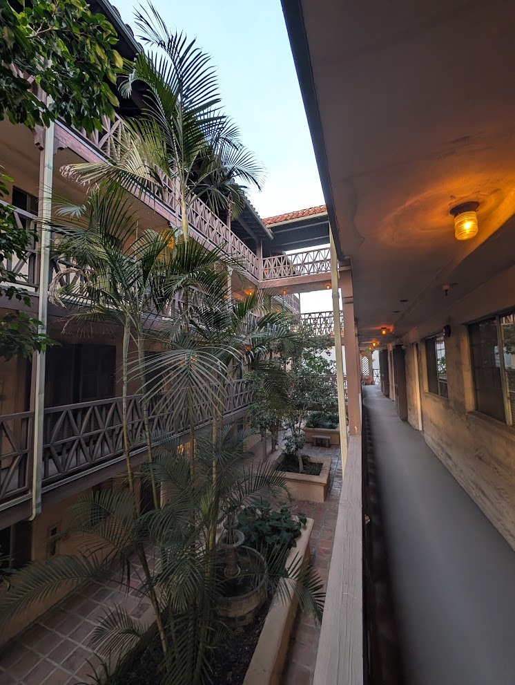 A long corridor with a balcony on the left and a long hallway on the right.