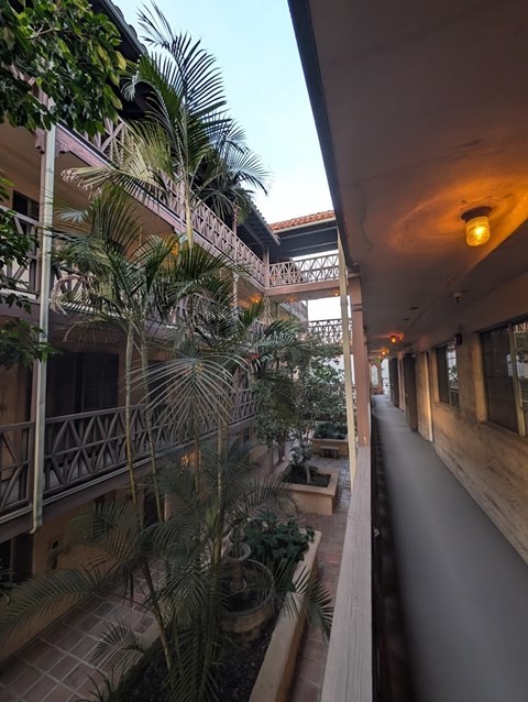 A long corridor with a balcony on the left and a long hallway on the right.