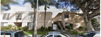 A sunny day at a residential area with cars parked on the street.