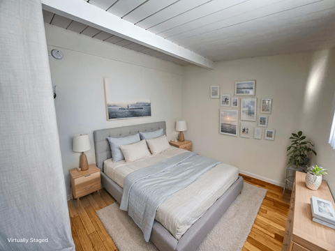 A bedroom with a bed, nightstands, and pictures on the wall.