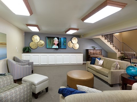 A living room with a couch, chairs, and a television.