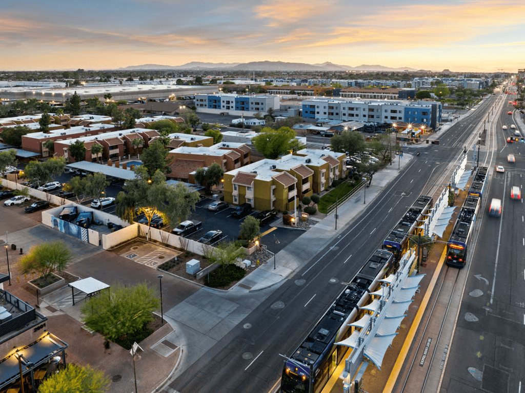 A city street with buses and cars on a sunny day.