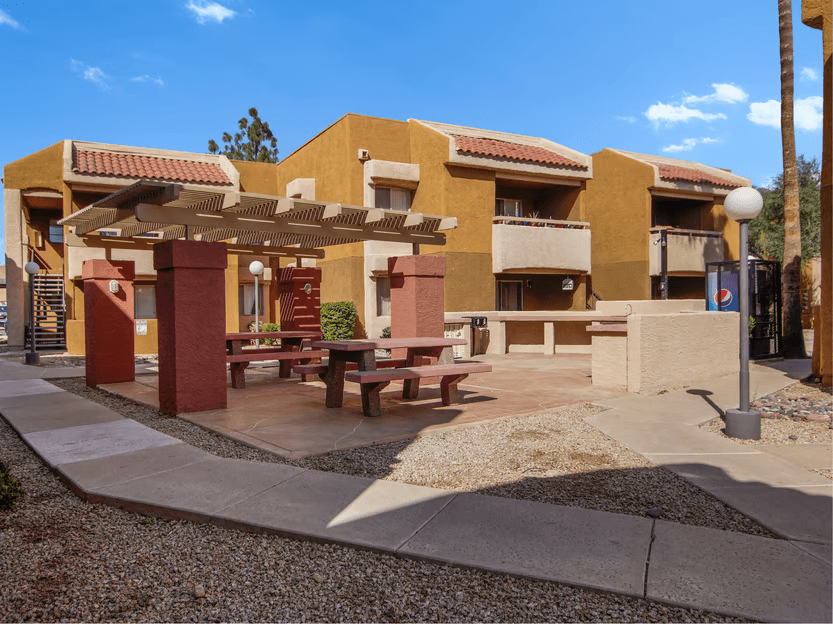 A building with a red roof and a patio with a table and chairs.