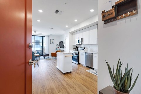 A kitchen with white cabinets and a wooden floor.