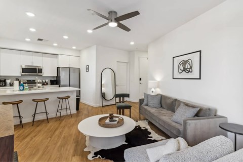 A modern living room with a grey couch and a white coffee table.