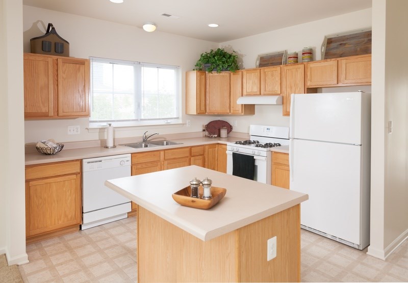 A kitchen with wooden cabinets and white appliances.
