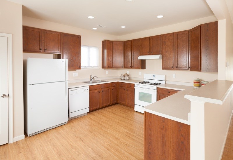 A kitchen with wooden cabinets and white appliances.